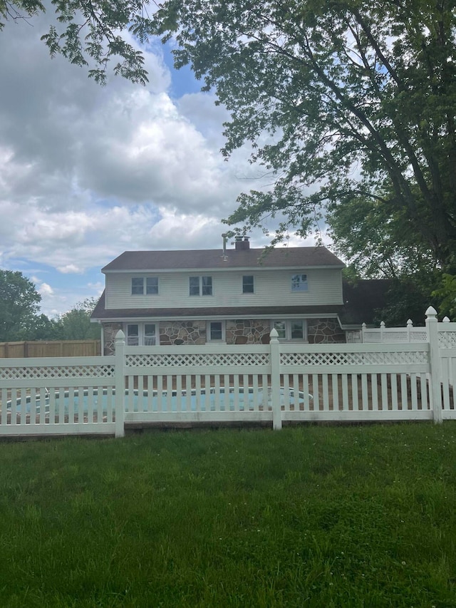 back of property featuring a lawn