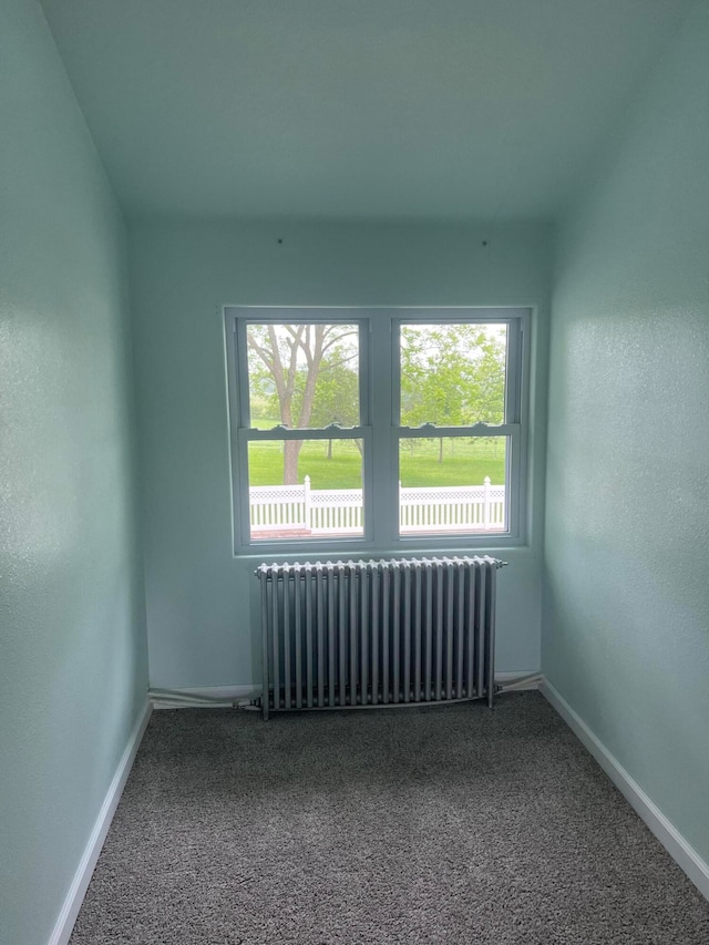 carpeted empty room featuring radiator