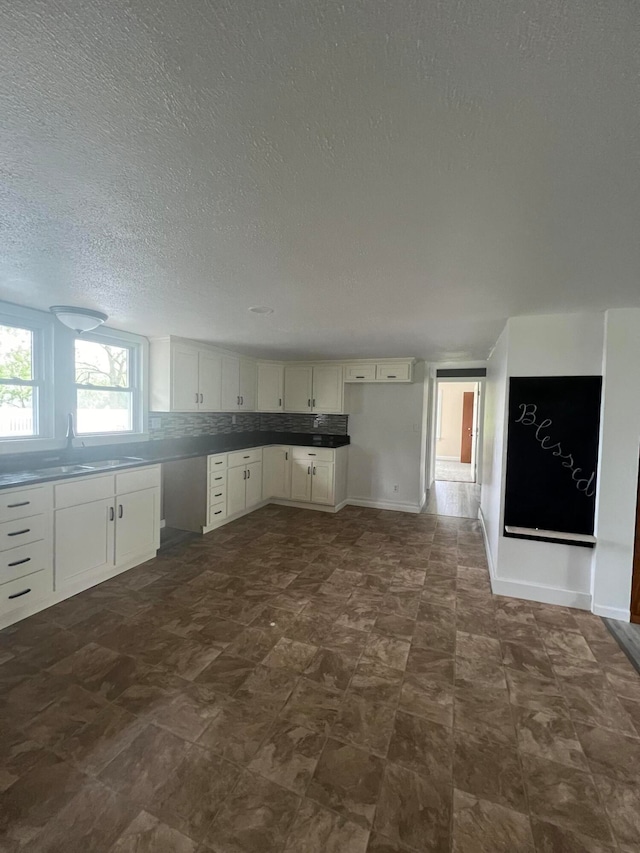 kitchen with white cabinetry and a textured ceiling