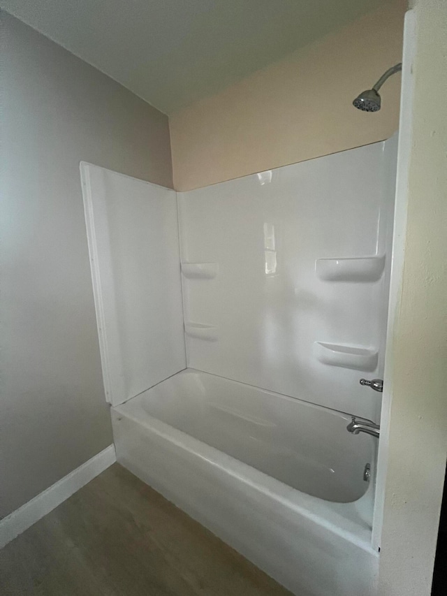 bathroom with hardwood / wood-style flooring and shower / bathtub combination