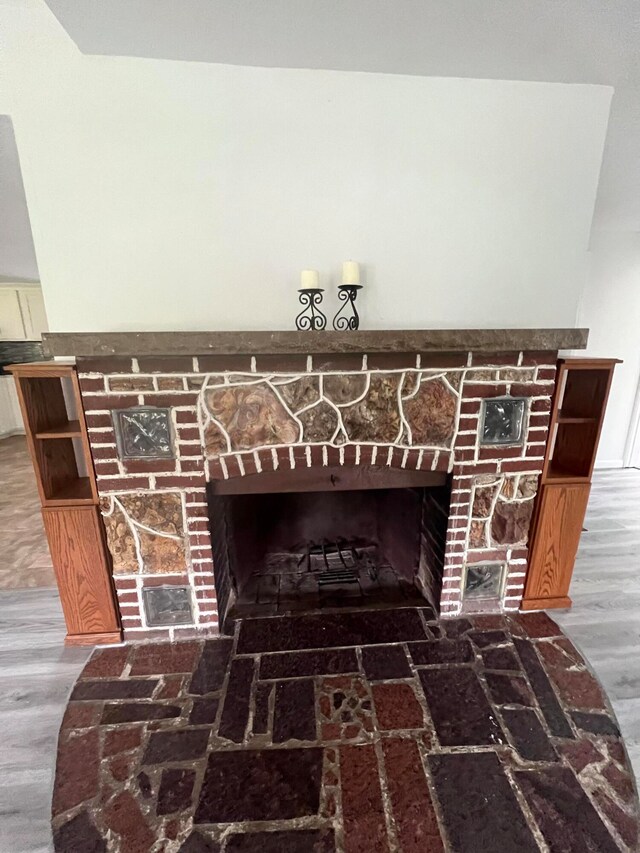 details featuring a stone fireplace and wood-type flooring