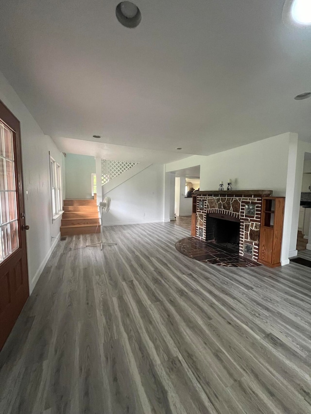 unfurnished living room featuring a brick fireplace and hardwood / wood-style floors