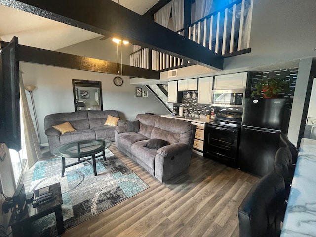 living room featuring hardwood / wood-style floors, beam ceiling, and high vaulted ceiling