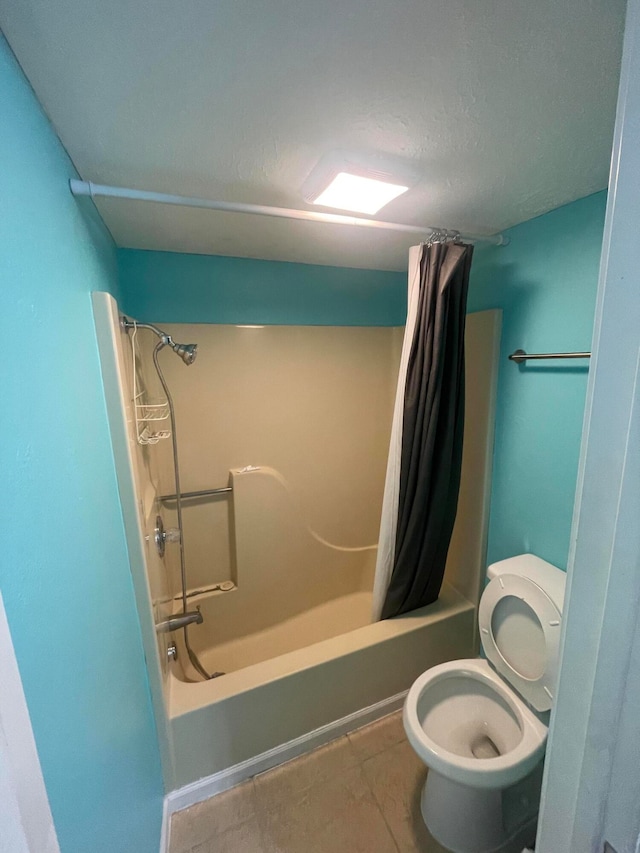 bathroom with tile patterned floors, toilet, shower / bath combo, and a textured ceiling