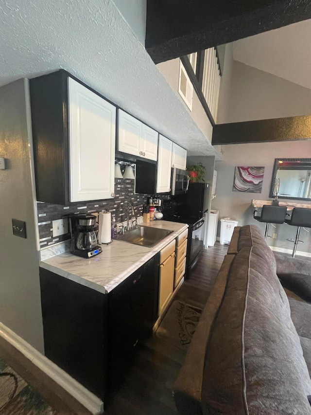 kitchen with dark wood-type flooring, sink, white cabinetry, and decorative backsplash