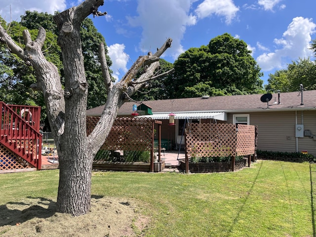 rear view of property featuring a wooden deck and a lawn