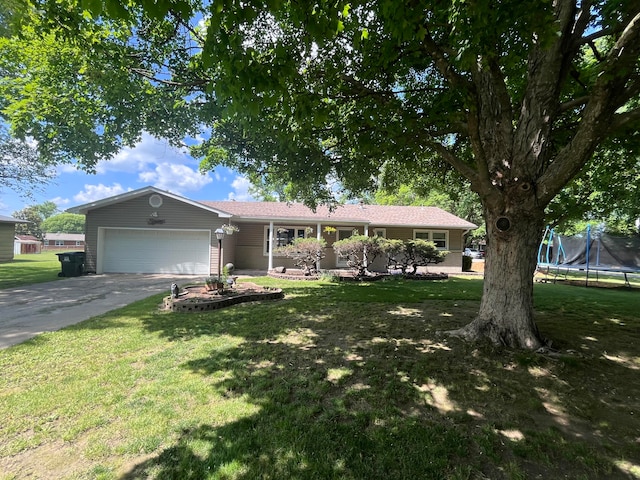 ranch-style house featuring a trampoline, a garage, and a front yard