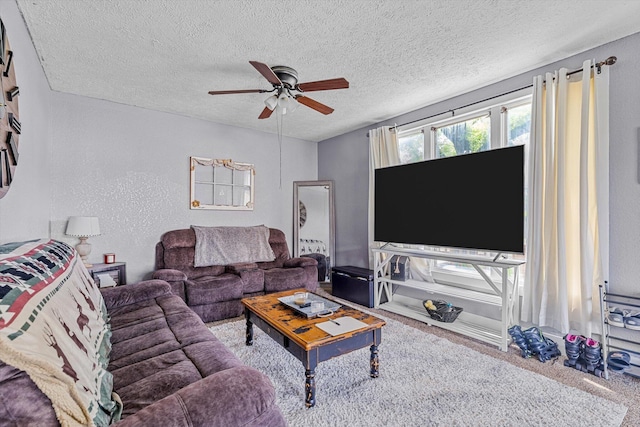 carpeted living room with ceiling fan and a textured ceiling