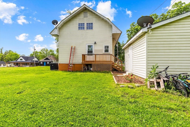 back of house featuring a deck, central air condition unit, and a lawn