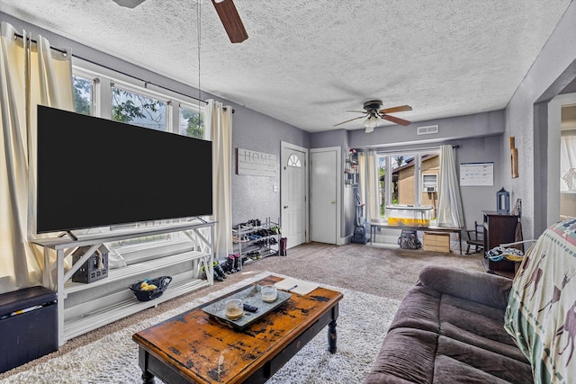 living room with a healthy amount of sunlight, ceiling fan, carpet floors, and a textured ceiling