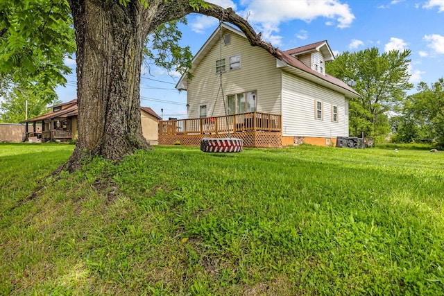 back of property with a wooden deck and a lawn