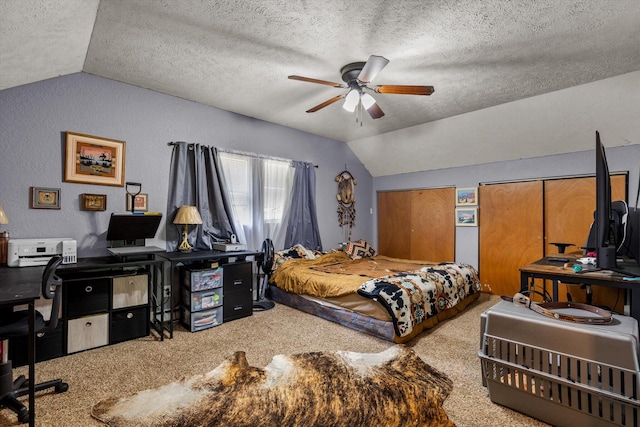 carpeted bedroom with lofted ceiling, two closets, a textured ceiling, and ceiling fan