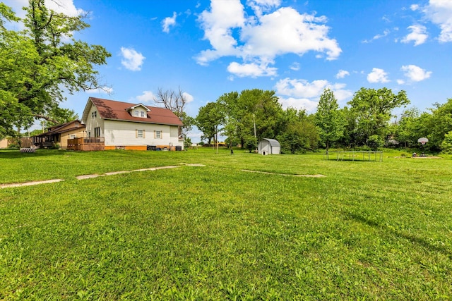 view of yard featuring a deck and a storage shed