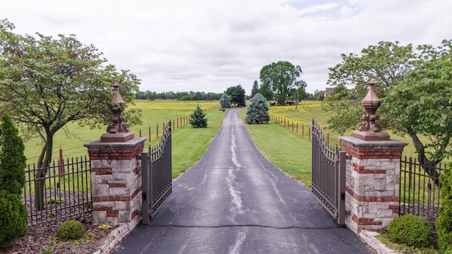 view of gate featuring a yard and a rural view