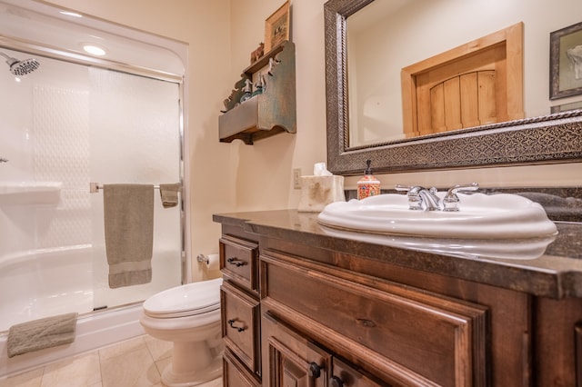 bathroom with tile patterned floors, toilet, a shower with door, and vanity