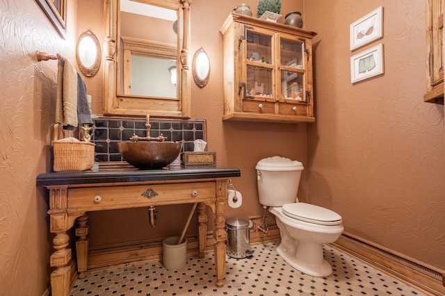 bathroom featuring tile patterned floors, vanity, toilet, and backsplash