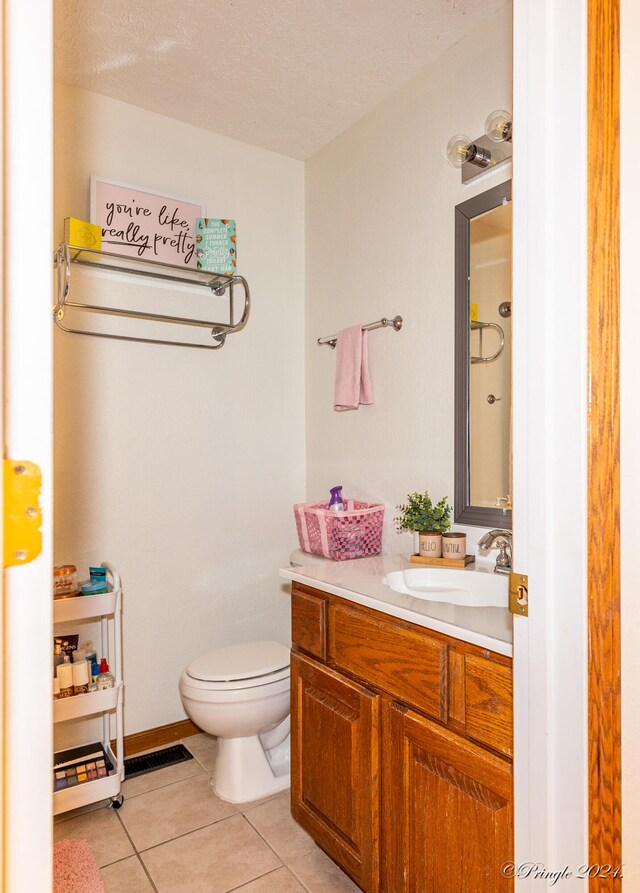 bathroom featuring tile patterned floors, toilet, vanity, and a textured ceiling