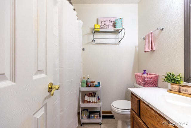 full bathroom featuring toilet, vanity, and tile patterned floors