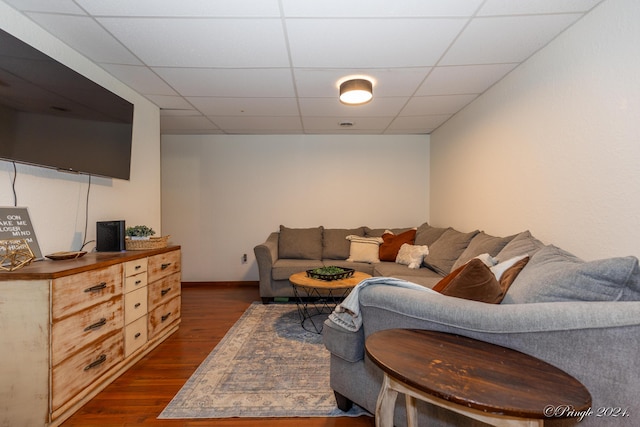 living room with a paneled ceiling, baseboards, and dark wood-style flooring