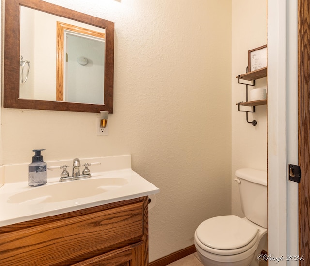 half bathroom with toilet, vanity, and baseboards