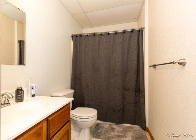 full bathroom with a shower with shower curtain, a textured wall, toilet, and vanity