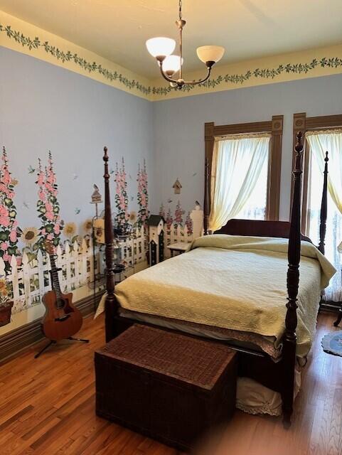 624 S Ash St, Nevada, MO 64772 - bedroom with an inviting chandelier and wood finished floors