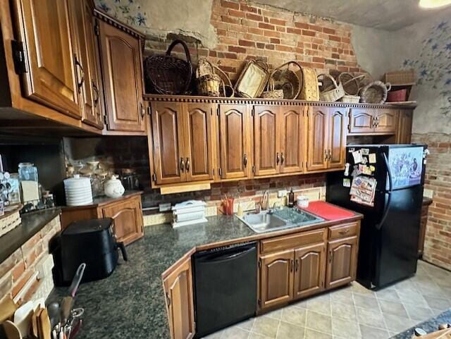 624 S Ash St, Nevada, MO 64772 - kitchen featuring dark countertops, a sink, black appliances, brown cabinets, and brick wall