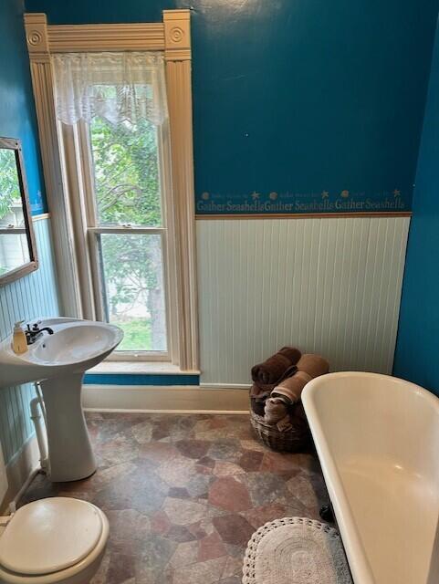 624 S Ash St, Nevada, MO 64772 - sitting room featuring stone finish floor, a wainscoted wall, and baseboards