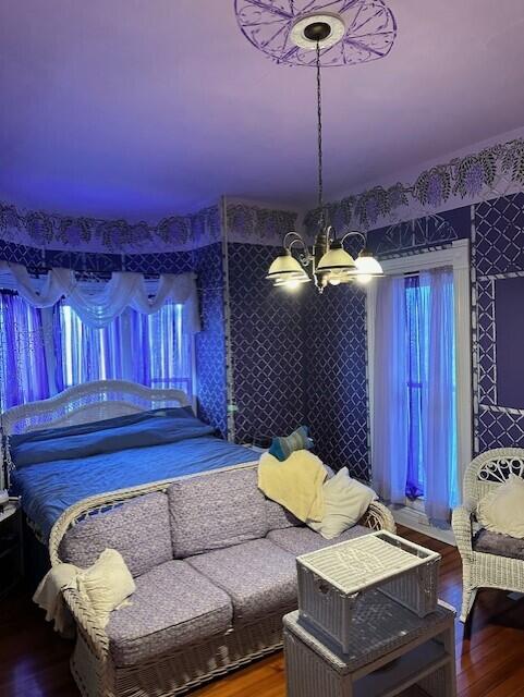 bedroom featuring an inviting chandelier and hardwood / wood-style flooring