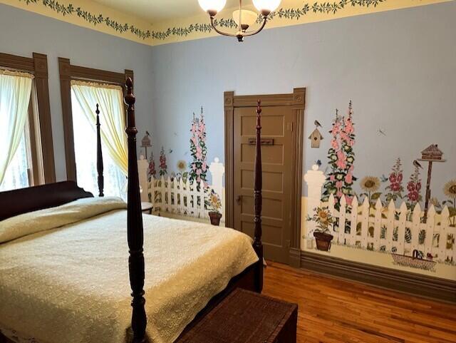 624 S Ash St, Nevada, MO 64772 - bedroom featuring a notable chandelier and wood finished floors