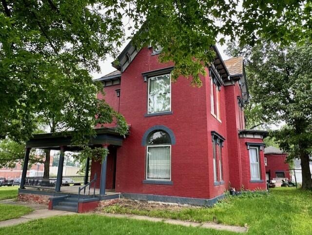 view of front of home with a porch and a front lawn