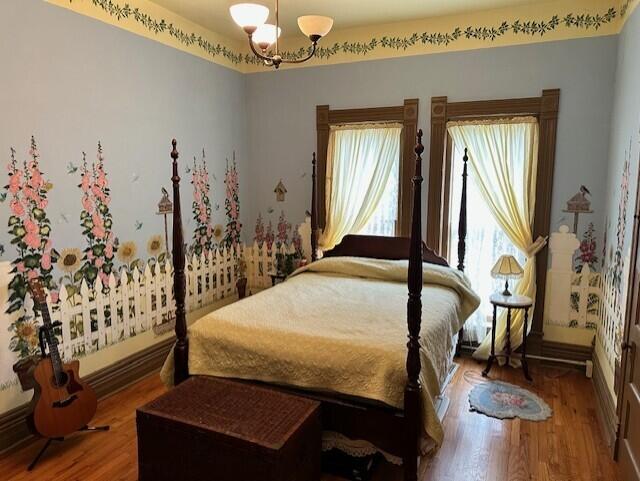 bedroom with a chandelier and hardwood / wood-style floors