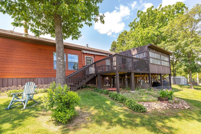 back of property featuring a storage shed, a lawn, and a deck