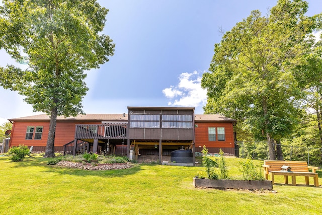 back of property with a lawn and a deck