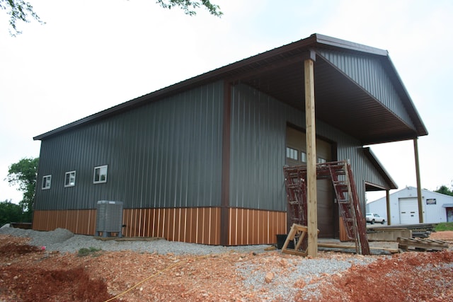 view of side of home featuring central AC and an outdoor structure