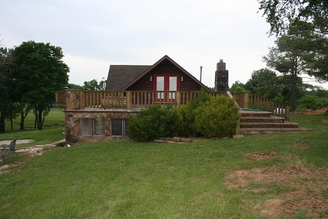 back of house with a lawn, a wooden deck, and french doors