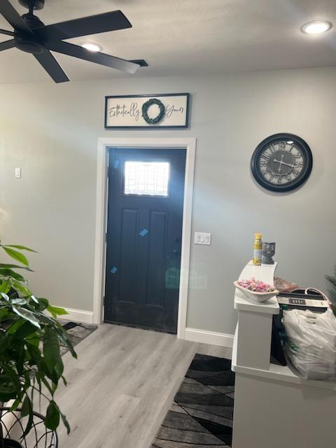 entryway with ceiling fan and wood-type flooring