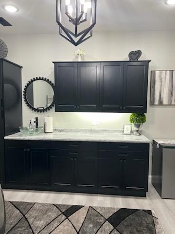 kitchen featuring light wood-type flooring, an inviting chandelier, and sink