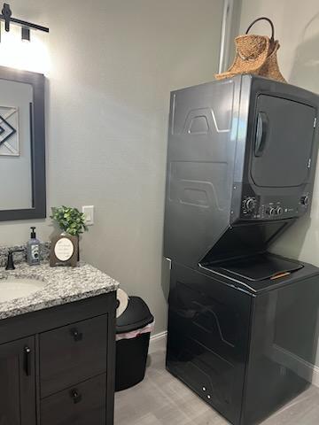 laundry area featuring sink and stacked washing maching and dryer