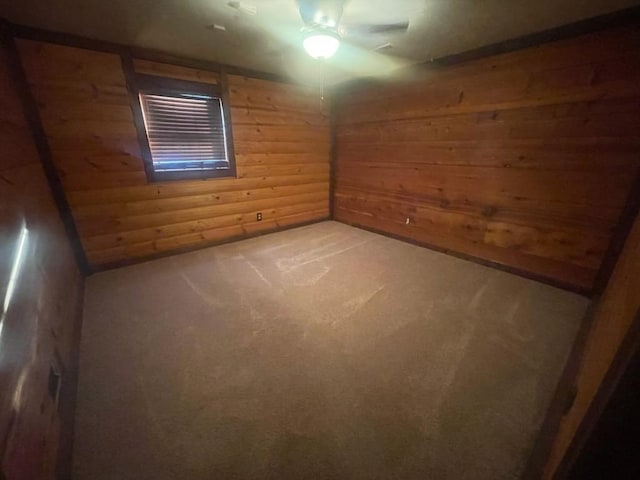 spare room with carpet flooring and wood walls