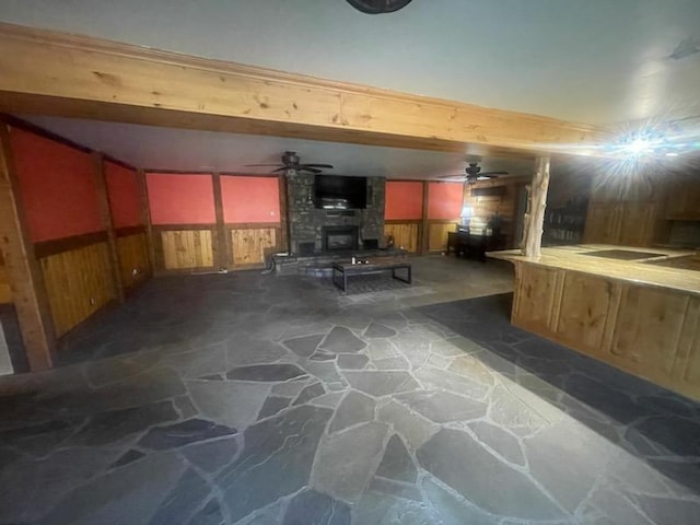 basement with ceiling fan and a fireplace