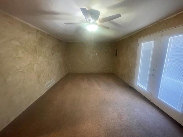 empty room featuring ceiling fan and carpet