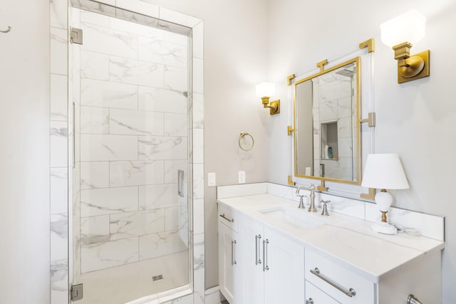 bathroom featuring a shower with door and vanity