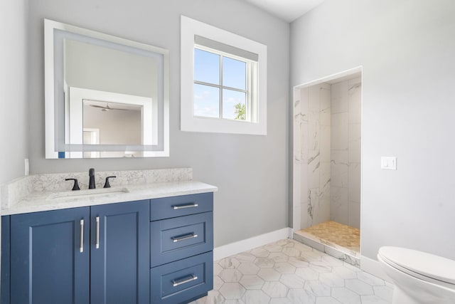 bathroom featuring tile patterned flooring, vanity, tiled shower, and toilet