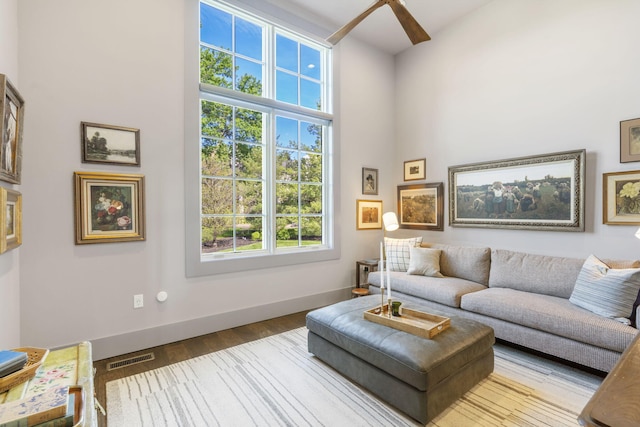 living room with light wood-type flooring and a high ceiling