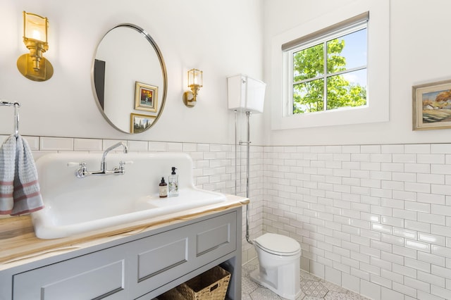 bathroom with tile patterned flooring, tile walls, vanity, and toilet