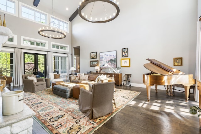 living room with a towering ceiling, french doors, an inviting chandelier, and dark hardwood / wood-style flooring