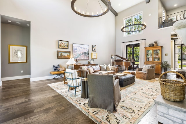 living room featuring a high ceiling, dark hardwood / wood-style floors, and an inviting chandelier