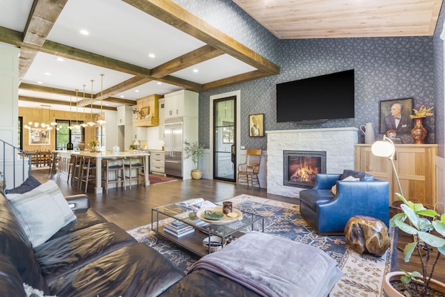 living room with dark hardwood / wood-style floors, a fireplace, coffered ceiling, an inviting chandelier, and beam ceiling