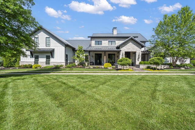 5233 S Stirling Way, Springfield, MO 65809 - view of front facade featuring a front lawn, stone siding, a standing seam roof, and metal roof